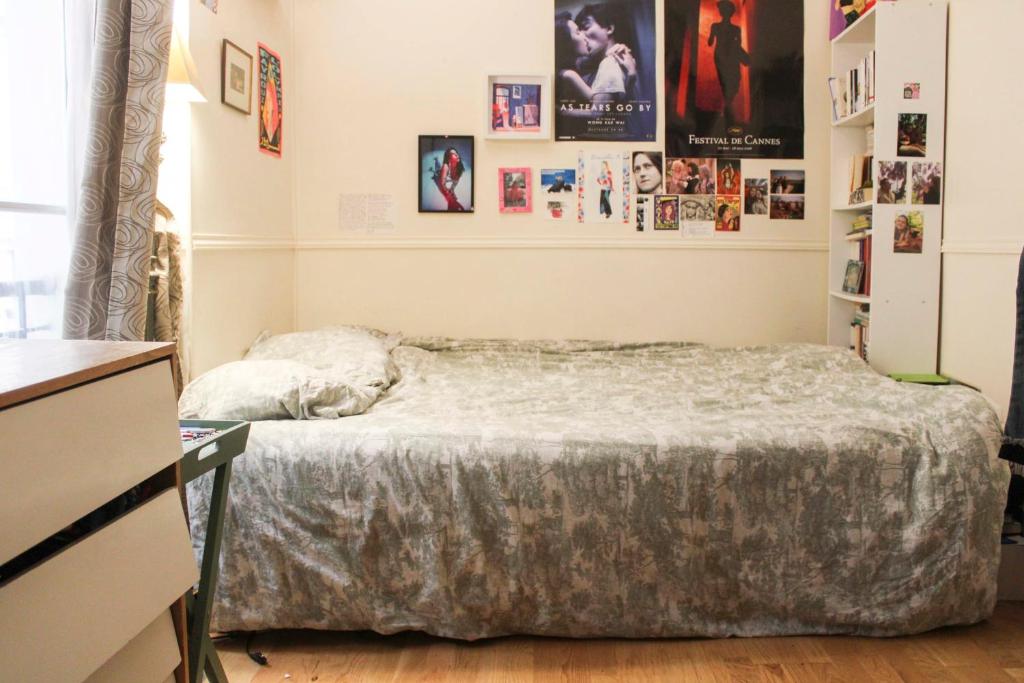 a bedroom with a bed in a room with pictures on the wall at Apartment near the Marais in Paris