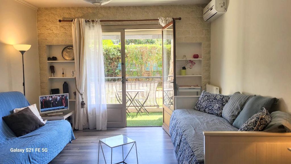 un salon avec un canapé et une porte coulissante en verre dans l'établissement CANNES STUDIO - wifi, clim, à Cannes