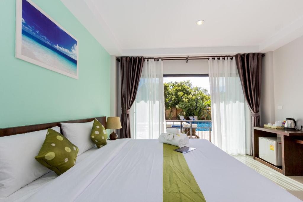 sypialnia z łóżkiem i dużym oknem w obiekcie Andaman Pearl Resort w Aonang Beach