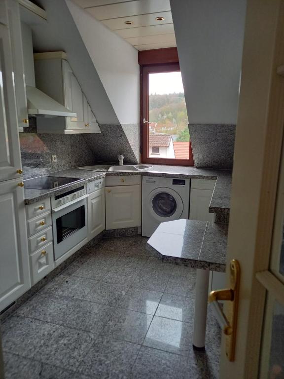 a kitchen with a washing machine and a window at Ferienwohnung Enz, 3 OG. in Pforzheim