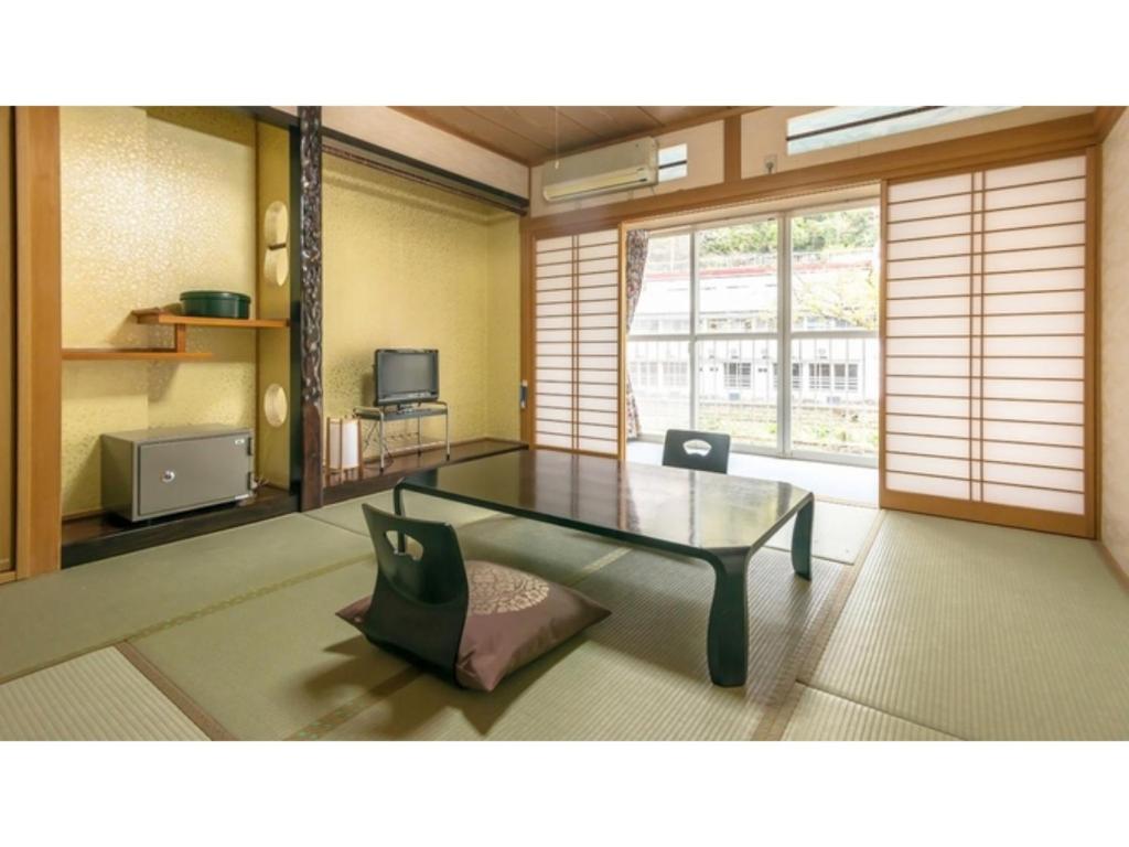 a living room with a glass table and a chair at Myoken Onsen Nemu - Vacation STAY 20847v in Kirishima
