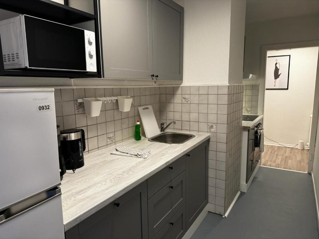 a kitchen with a sink and a microwave at 5-Bett Wohnung im Boardinghaus Elisabeth in Dinslaken