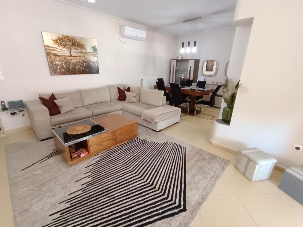 a living room with a couch and a table at NEW elegant roof apartment in Acharnes