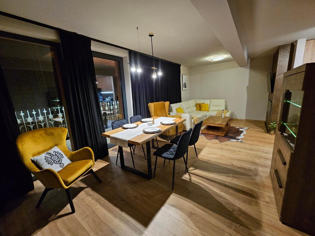 a dining room and living room with a table and chairs at Apartament RS6 in Zakopane