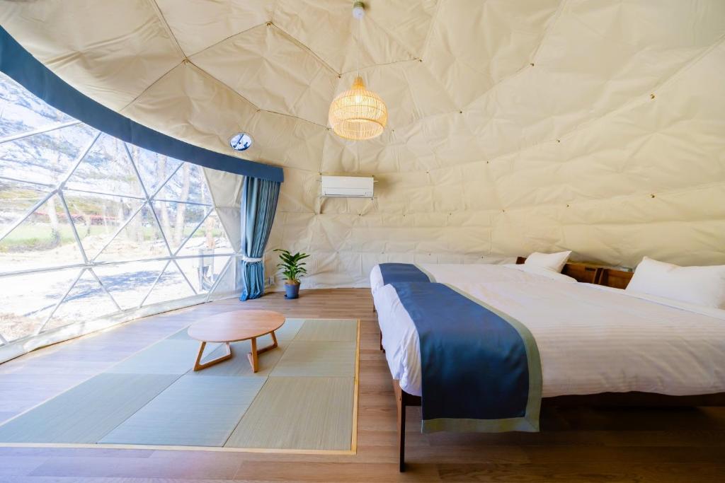 a bedroom with a bed and a large window at NAGOMI CAMP - Vacation STAY 48653v in Nasushiobara