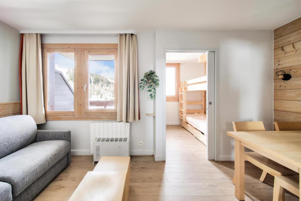 - un salon avec un canapé, une table et des lits superposés dans l'établissement Résidence Plagne Lauze - maeva Home - Studio 4 personnes - Prestige MAE-1944, à Mâcot La Plagne