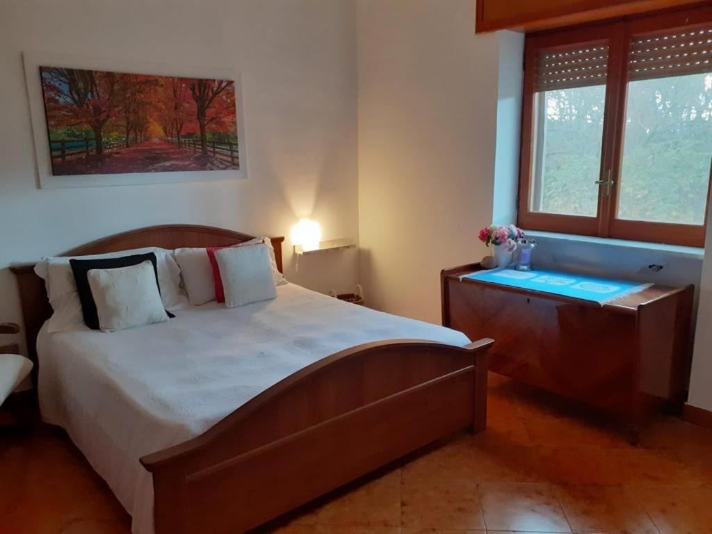 - une chambre avec un lit, une commode et une fenêtre dans l'établissement Casa i Quattro Alberi, à Montemiletto