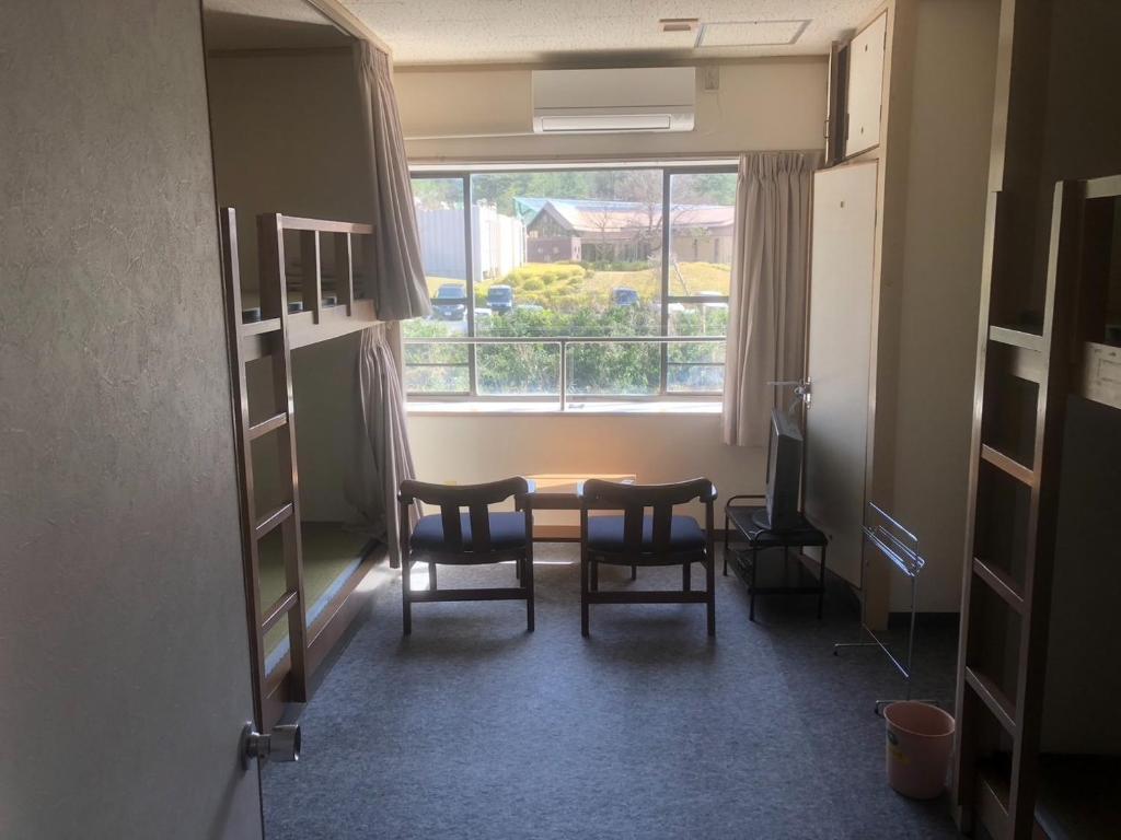 a room with a table and chairs and a window at Guesthouse Sunaen - Vacation STAY 49057v in Tottori