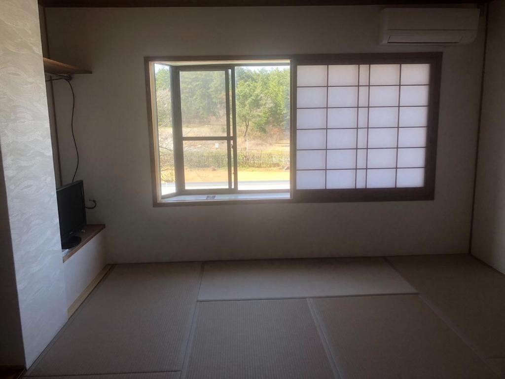 鳥取市にあるGuesthouse Sunaen - Vacation STAY 49055vの窓とテレビが備わる空き部屋