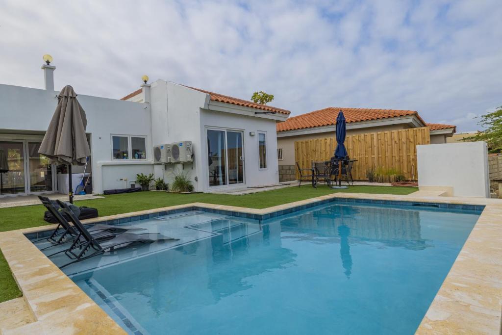 una piscina frente a una casa en Adele's Apartment with Pool, 5 minutes walk to the beach, en Palm-Eagle Beach