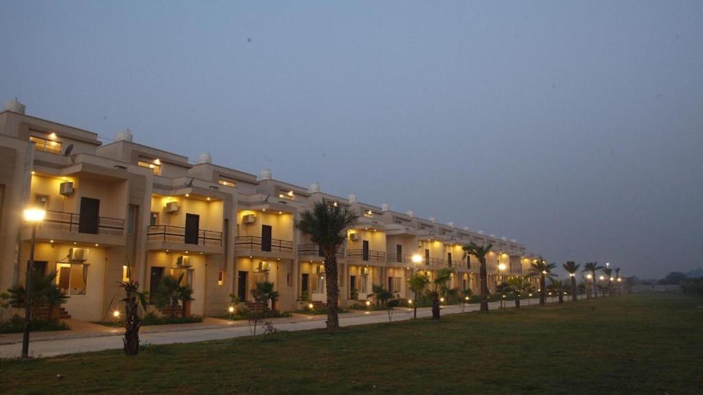 un grande edificio bianco con luci accese di notte di Vrindavan serenity hotel & suites a Vrindāvan