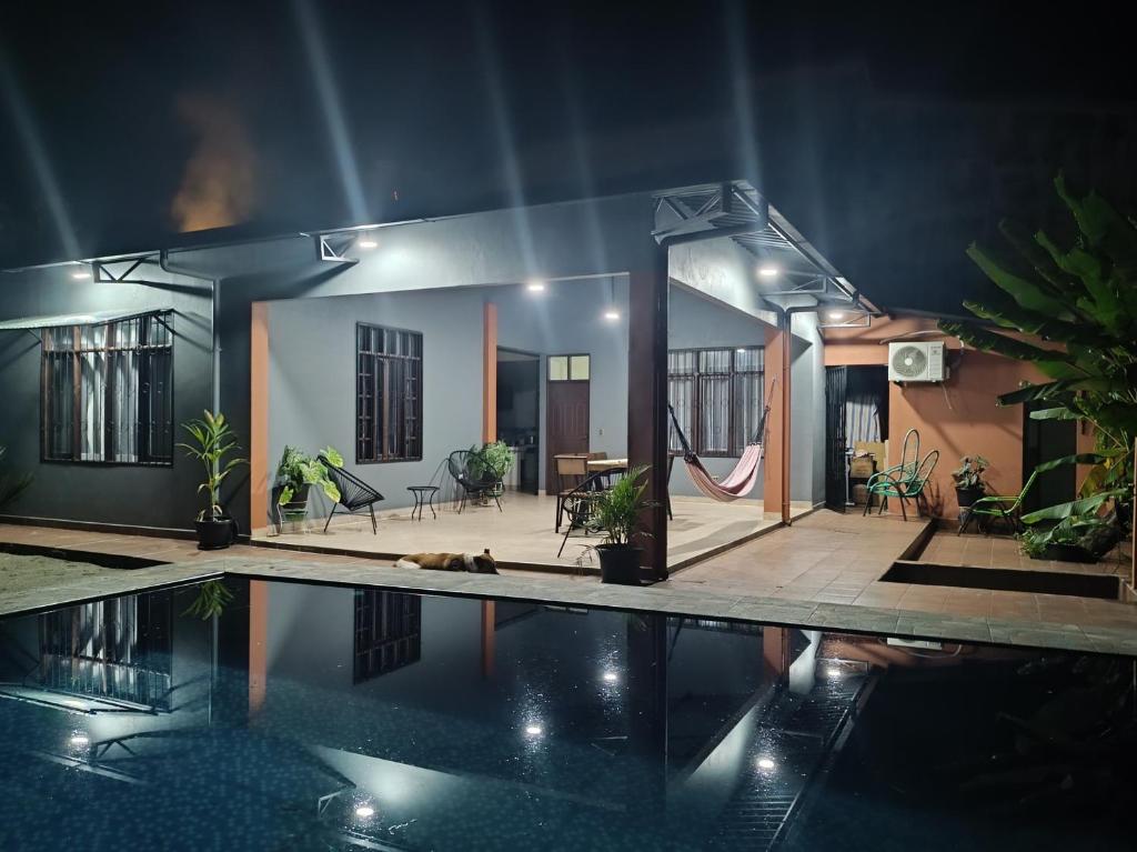 una casa con piscina por la noche en Casa de huespedes con piscina privada en Villa Tunari