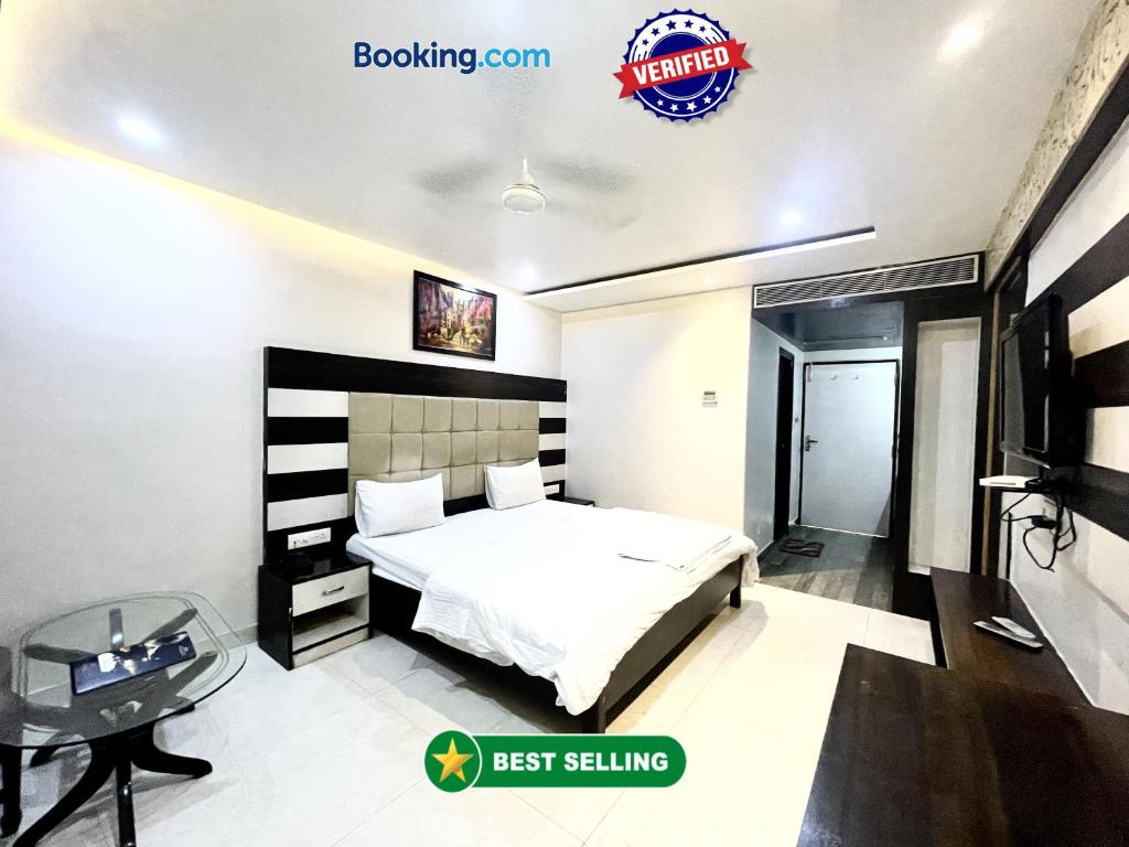 Schlafzimmer mit einem Bett, einem Schreibtisch und einem TV in der Unterkunft HOTEL P PALACE ! VARANASI fully-Air-Conditioned-hotel lift-and-Parking-availability, near Kashi Vishwanath Temple, and Ganga ghat in Varanasi