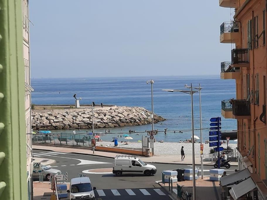- une vue sur une plage avec des voitures garées dans une rue dans l'établissement LaCamiHome, à Menton