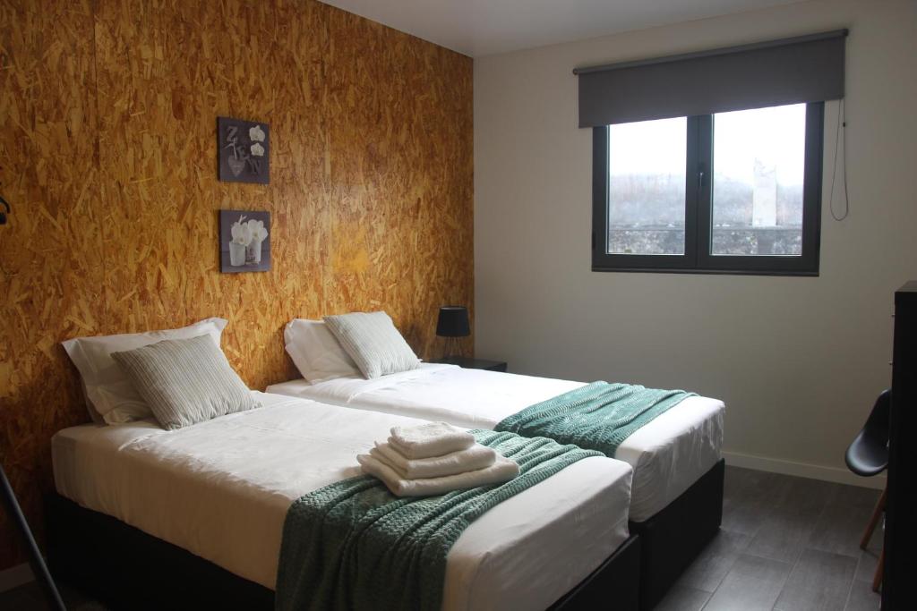 een slaapkamer met 2 bedden en handdoeken bij Casa D'Alegria in Ponta Delgada