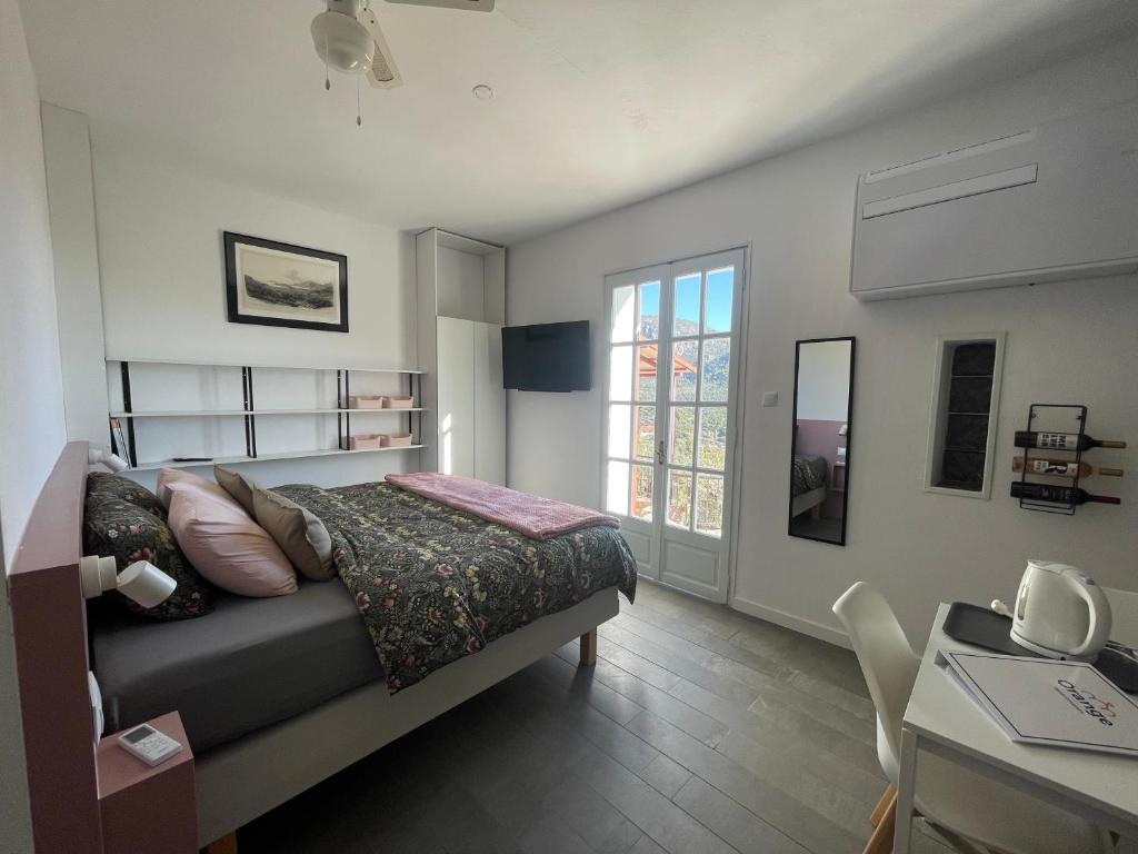 1 dormitorio con cama, escritorio y ventana en Orange Apartments, en Epáno Epídhavros