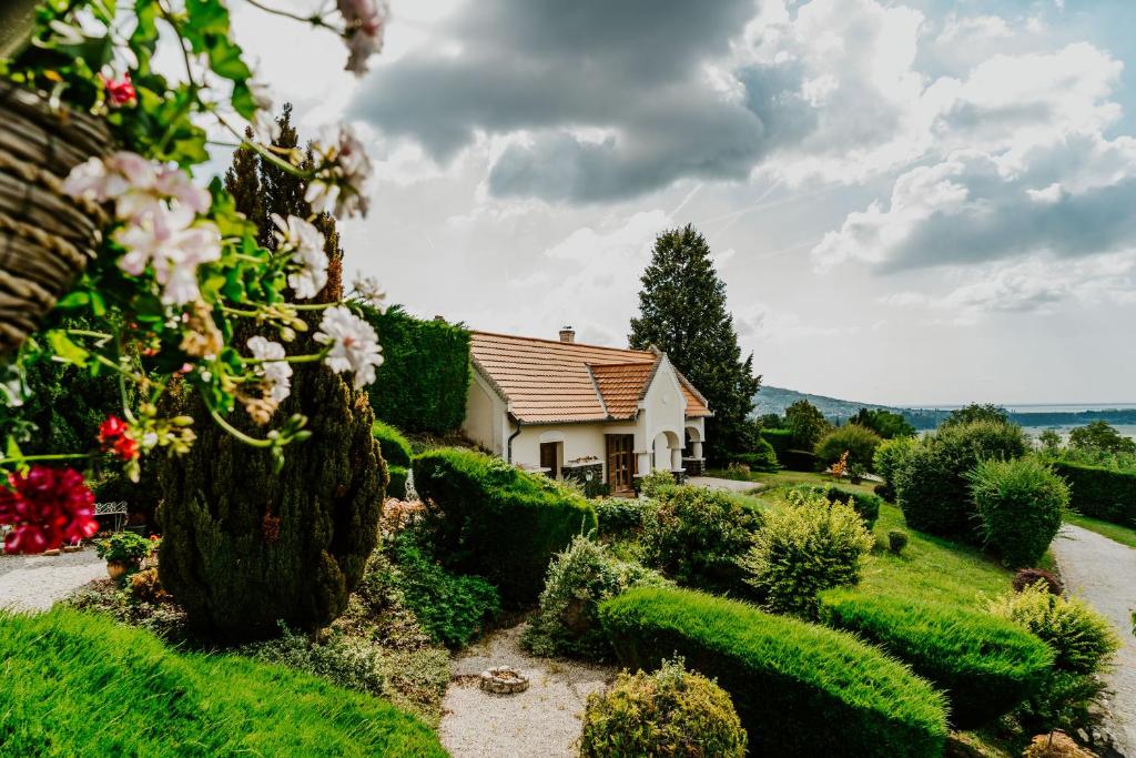 HegymagasにあるHársfa Vendégházの茂みと花の庭園内の家