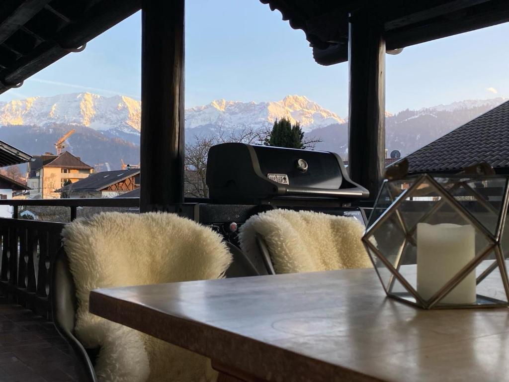 uma mesa e cadeiras com vista para as montanhas em Ferienwohnung Eckenhütte em Garmisch-Partenkirchen