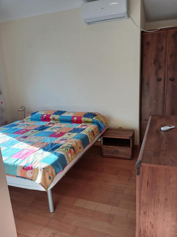 a bedroom with a bed with a colorful quilt on it at Apartman sa bazenom in Radovići