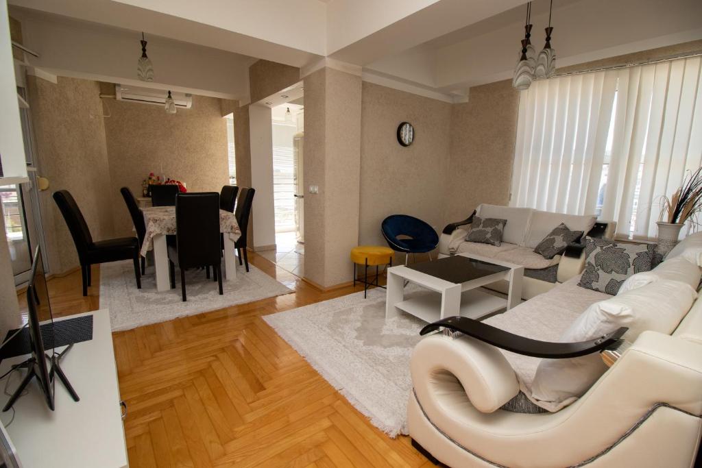 uma sala de estar com um sofá branco e uma mesa em APARTMENTS ANI em Ulcinj
