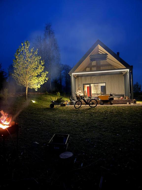 a house with a fire in the yard at night at Uzdaryta in Molėtai