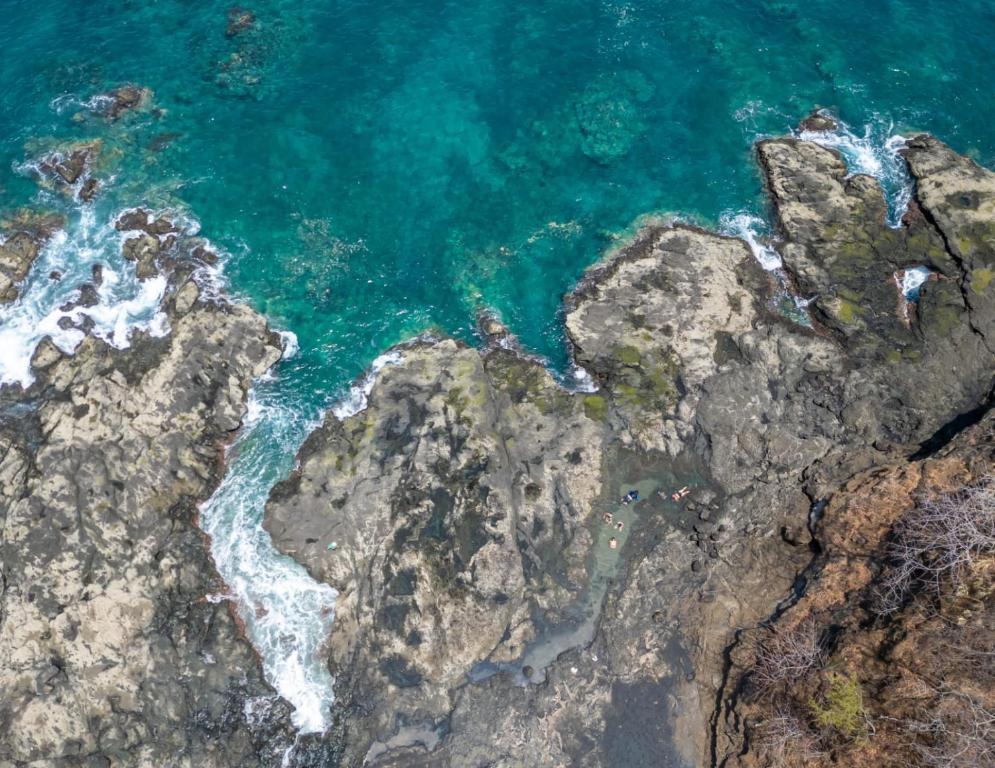 an aerial view of the ocean and rocks at Tylers Place Home in Coco
