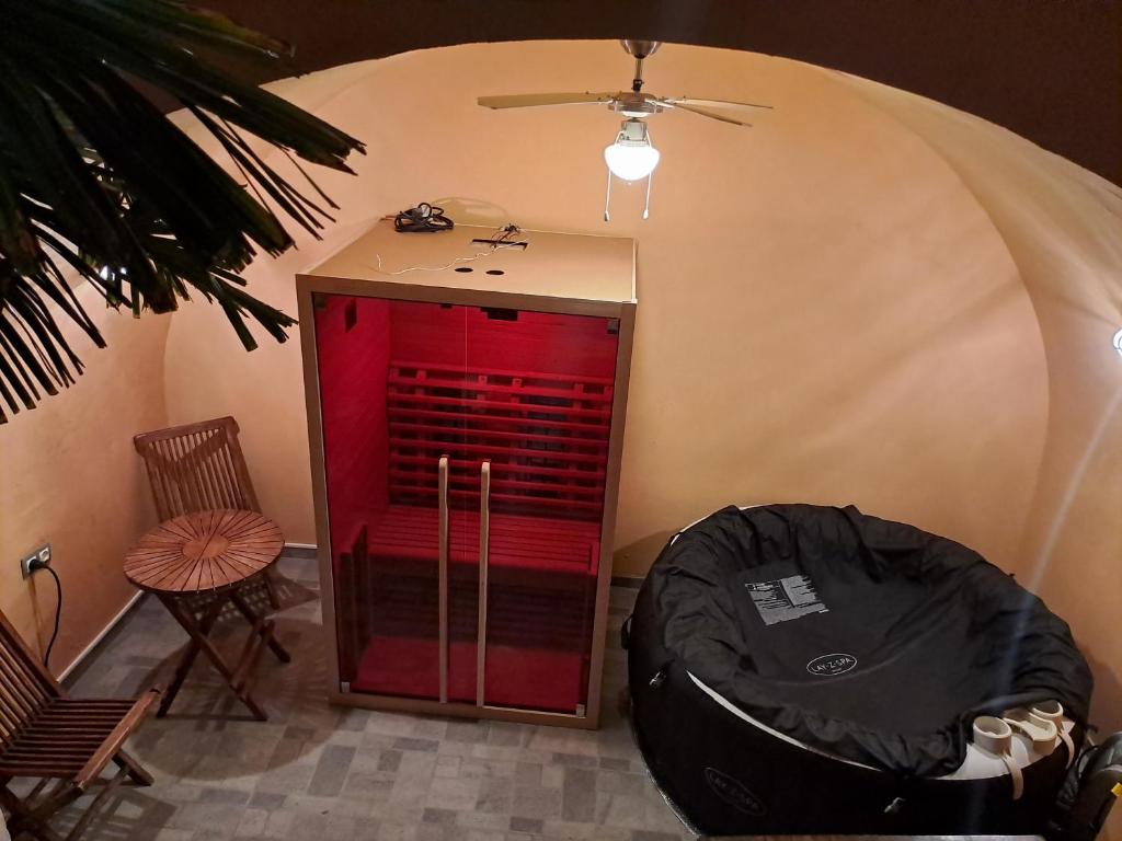 a room with a red cabinet and a chair at Atraktivna kuca sa saunom i grijanim jacuzzijem in Cres