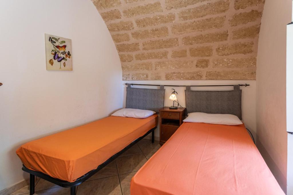 Łóżko lub łóżka w pokoju w obiekcie Villetta Jasmine con giardino Torre Pali