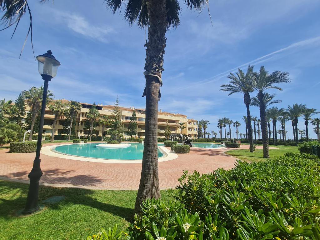 ロケタス・デ・マルにあるVilla Romana con piscina privada y vistas al jardínのヤシの木とスイミングプールのあるリゾート
