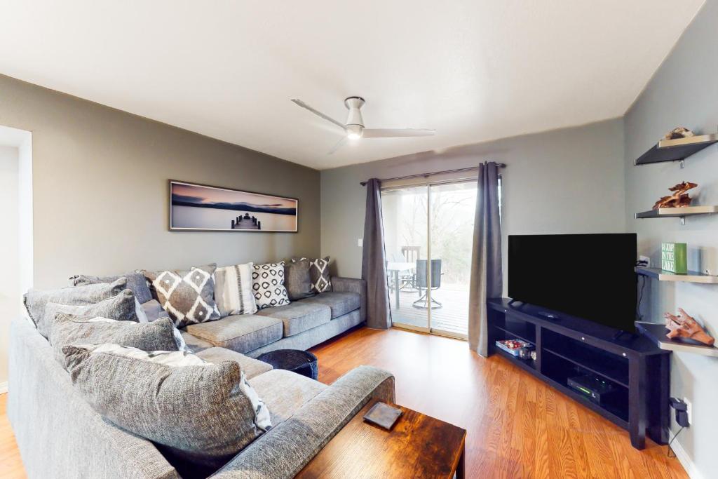 een woonkamer met een bank en een flatscreen-tv bij The Adventure Pad, Unit 1 in Branson