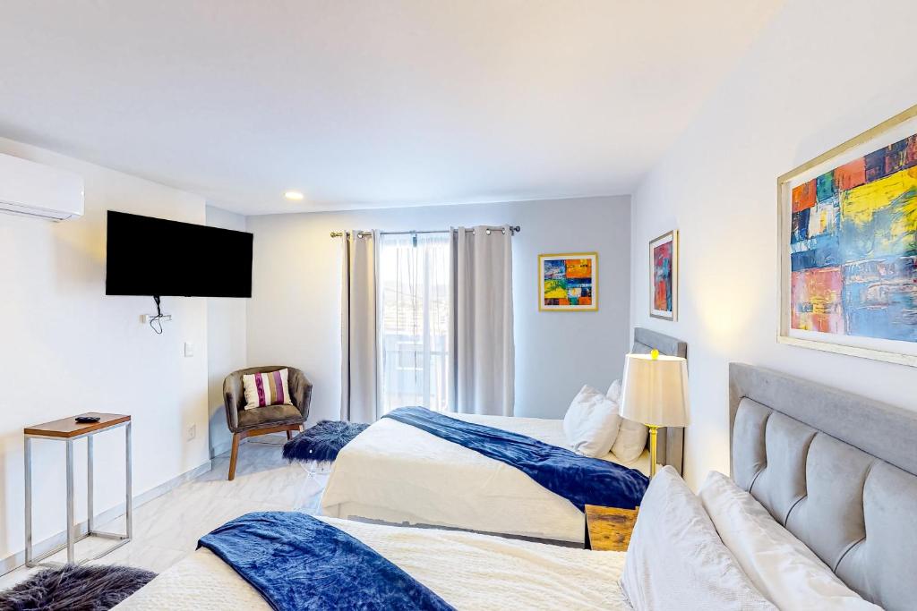 um quarto de hotel com duas camas e uma televisão em Sophie 203b at Morgan Residences em Cabo San Lucas