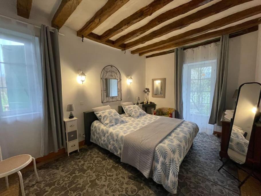 um quarto com uma cama e uma grande janela em Gîte La Carillonnerie em Bossay-sur-Claise