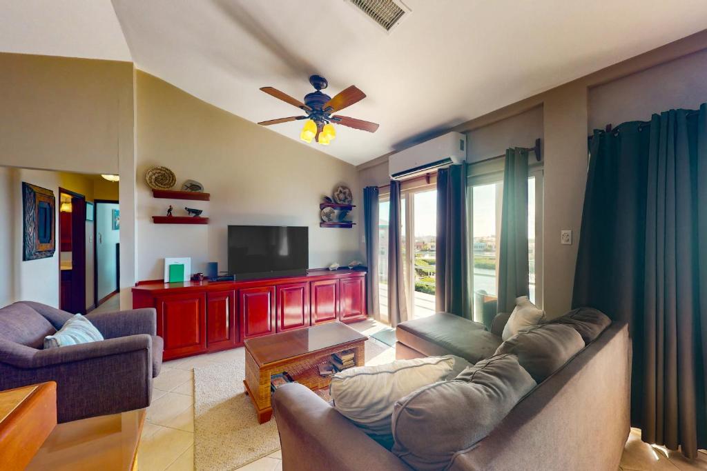 uma sala de estar com um sofá e uma televisão de ecrã plano em Suite B301 at Mara Laguna em San Pedro