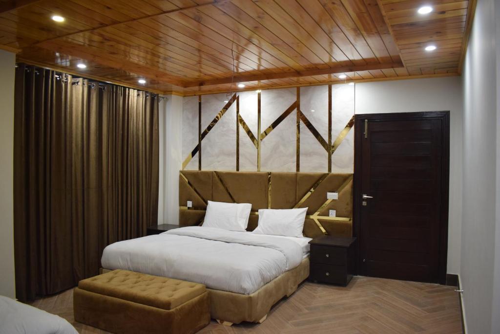 a bedroom with a king sized bed and a stool at The Heights Nathiagali in Nathia Gali