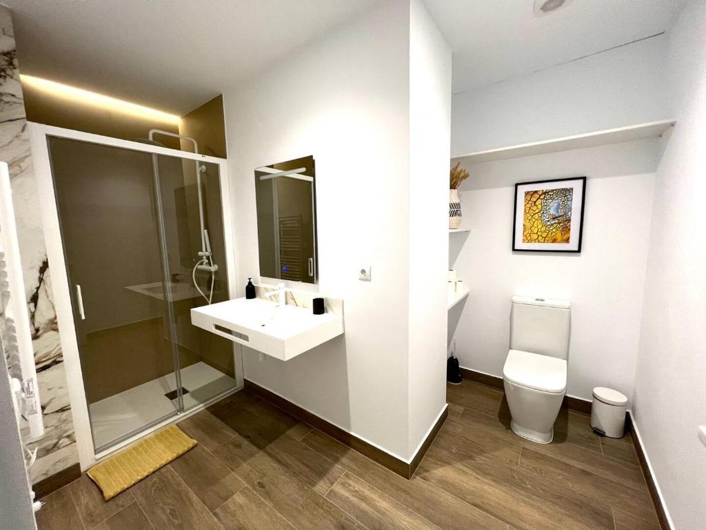 uma casa de banho branca com um lavatório e um WC em Precioso estudio en les Corts Valencianes em Valência
