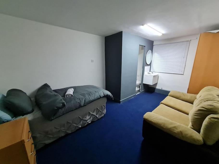 um quarto com um sofá e uma cama em Room near East Midland Airport 6 em Kegworth