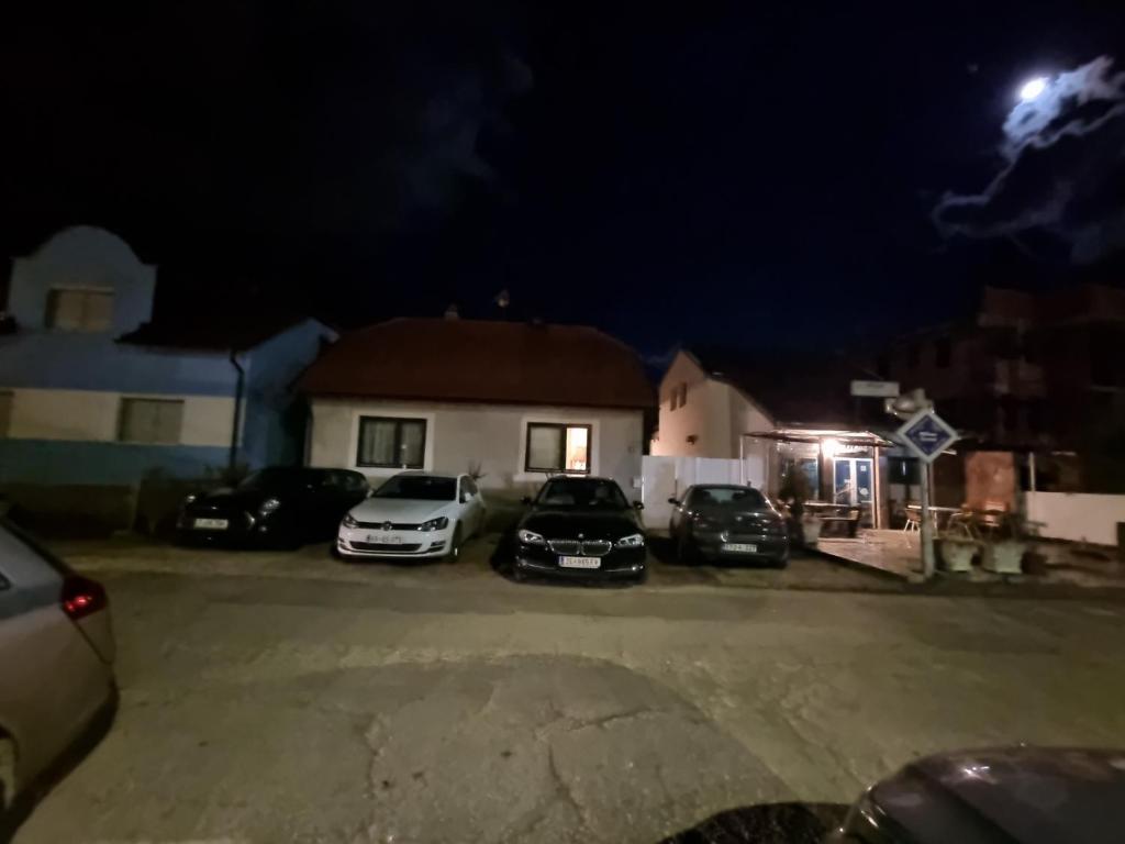 比哈奇Hostel Mlinar的一群晚上停在停车场的汽车