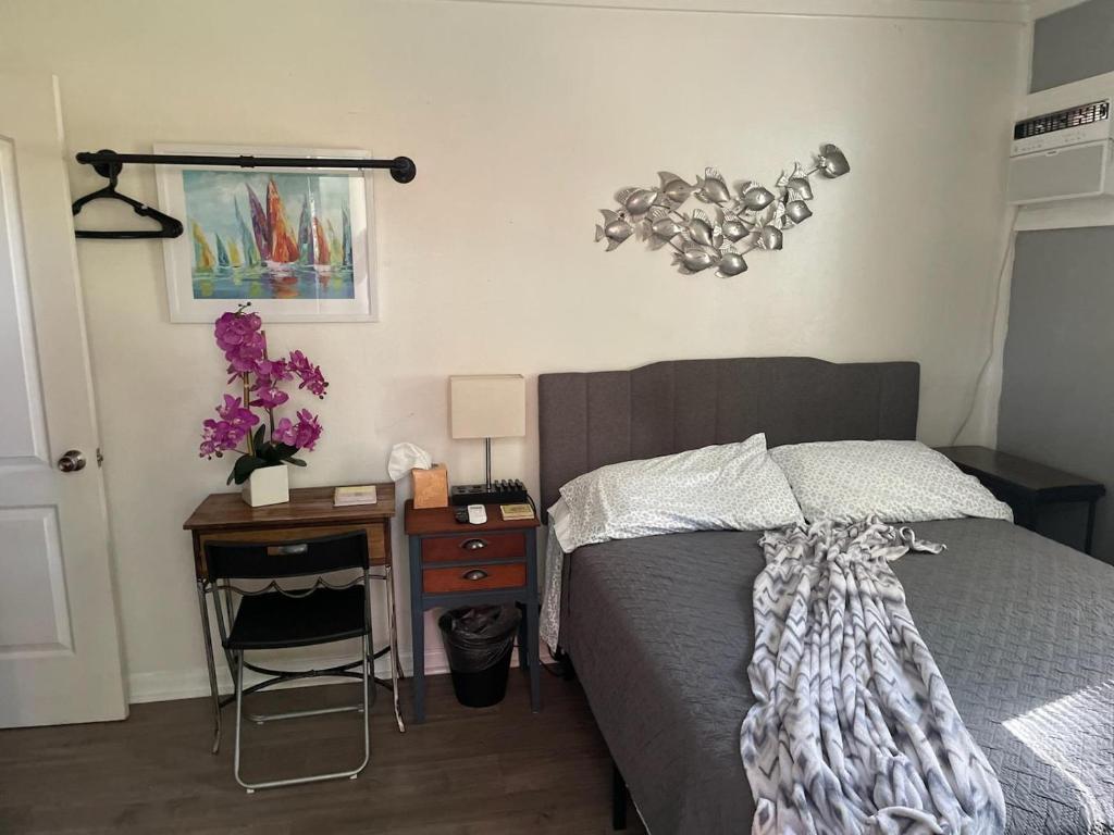 a bedroom with a bed and a table with a night stand at Lovely Studio Apartment with Kitchenette. in Tampa