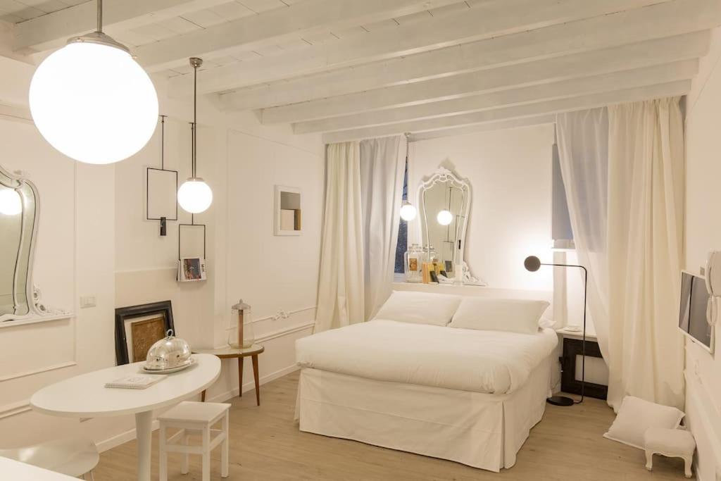 um quarto branco com uma cama e uma mesa em PUNTO FERMO in Verona center 023091-LOC-01911 em Verona