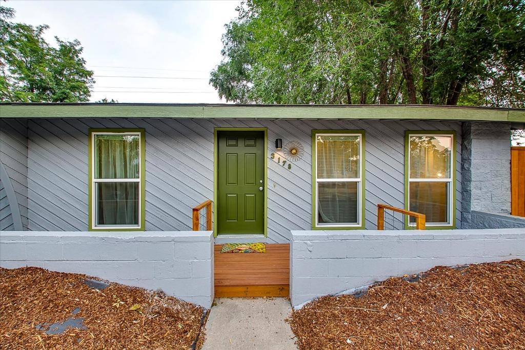 a small house with a green door and windows at Norton's River Crossing in Boise