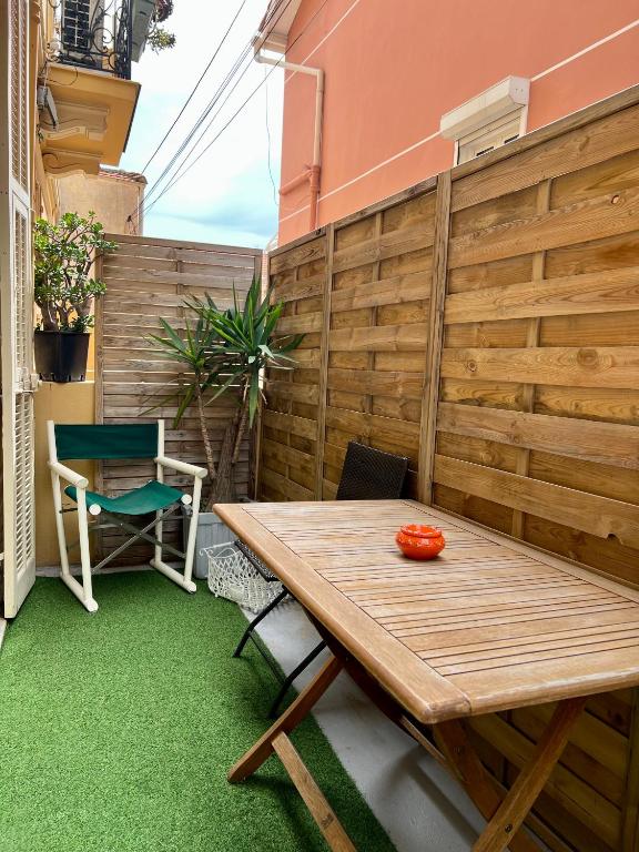 une terrasse avec une table en bois et une chaise dans l'établissement La Crémaillère confine Monte-Carlo, à Beausoleil