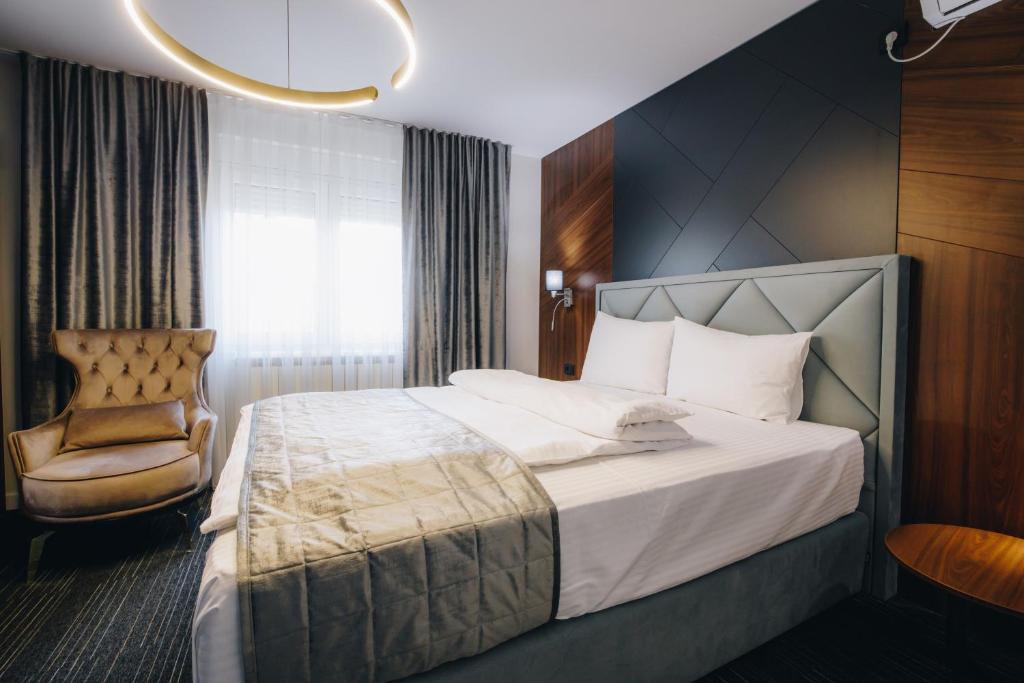 Pokój hotelowy z łóżkiem i krzesłem w obiekcie VILA RADOVIC ROOMS AND APARTMENTS w mieście Kragujevac