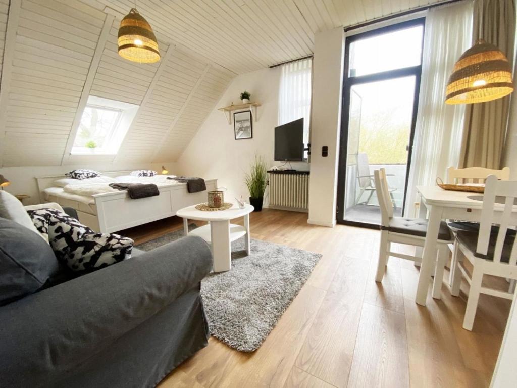 una sala de estar con un sofá y una mesa en Ferien im Wangerland - Haus Wiesenweg - Apartment 2 1OG, en Horumersiel