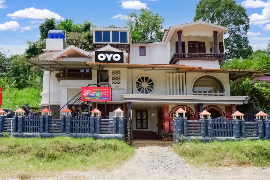 una casa vieja con un cartel ovy en ella en OYO Flagship Aiswarya Residency, en Wayanad