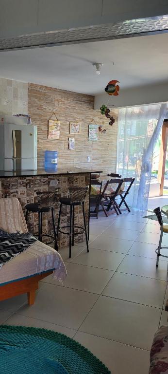 une salle avec des chaises et un comptoir avec des tables dans l'établissement Apto térreo com ar condicionado próximo a praia Maranduba, à Ubatuba