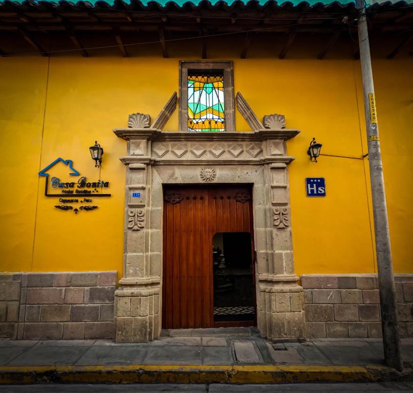 a yellow building with a door and a stained glass window at Casa Bonita Colonial in Cajamarca