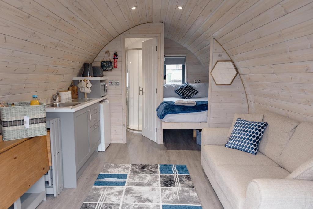 a living room with a couch and a bed in a tiny house at Coolaness Glamping in Irvinestown
