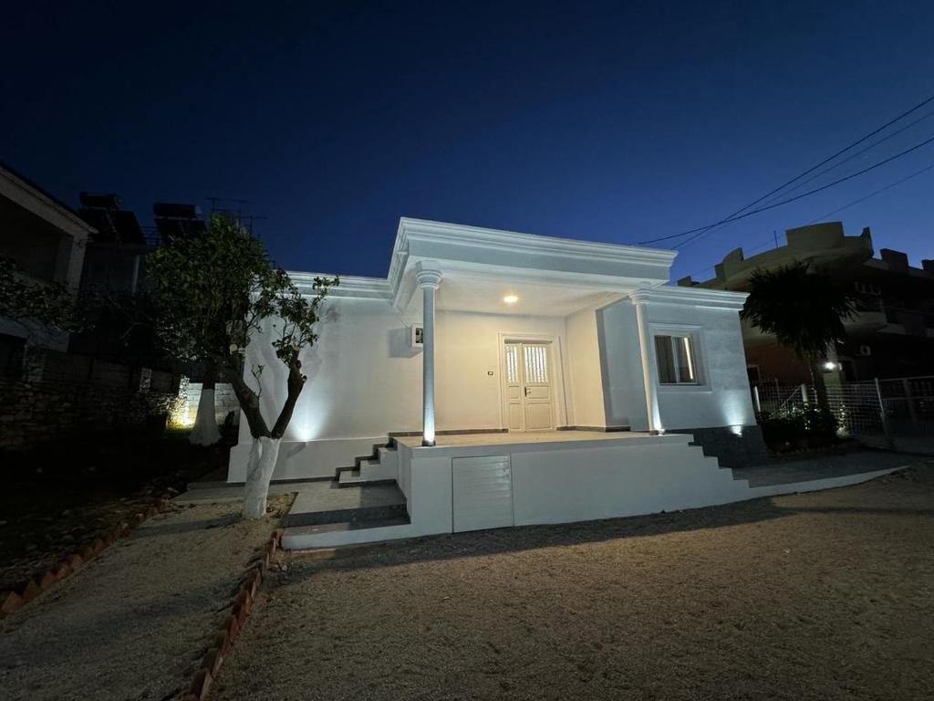 ein weißes Haus mit weißer Tür in der Nacht in der Unterkunft Vila Ademi Ksamil in Ksamil