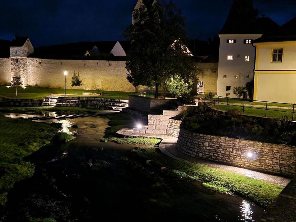 ein Gebäude mit einer Steinmauer und einem Fluss in der Nacht in der Unterkunft allio - das turmchalet in Berching