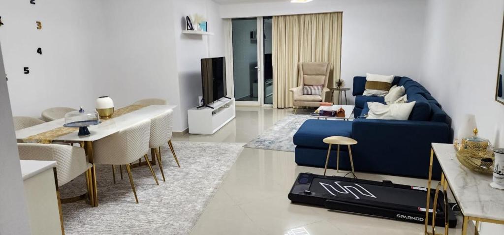 ein Wohnzimmer mit einem blauen Sofa und einem Tisch in der Unterkunft The blue residence in Abu Dhabi